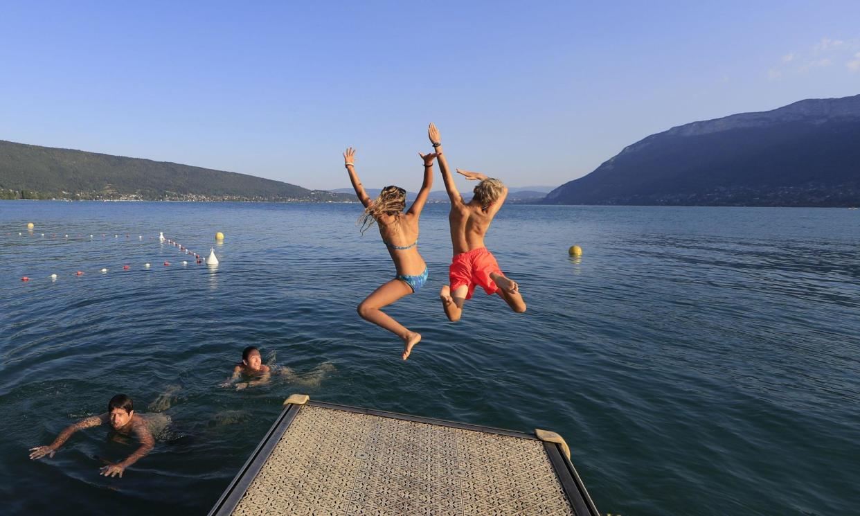 <span>Jumping into the pristine waters of Lake Annecy at Saint Jorioz beach.</span><span>Photograph: Hemis/Alamy</span>