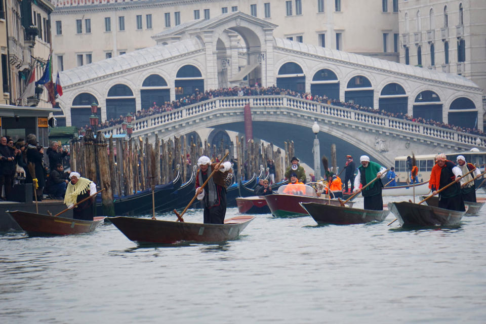 Gondoliers disguised as old women row on the Grand Canal in Venice, Italy, during the traditional Epiphany regatta Monday, Jan. 6, 2020 . (Anteo Marinoni/LaPresse via AP)