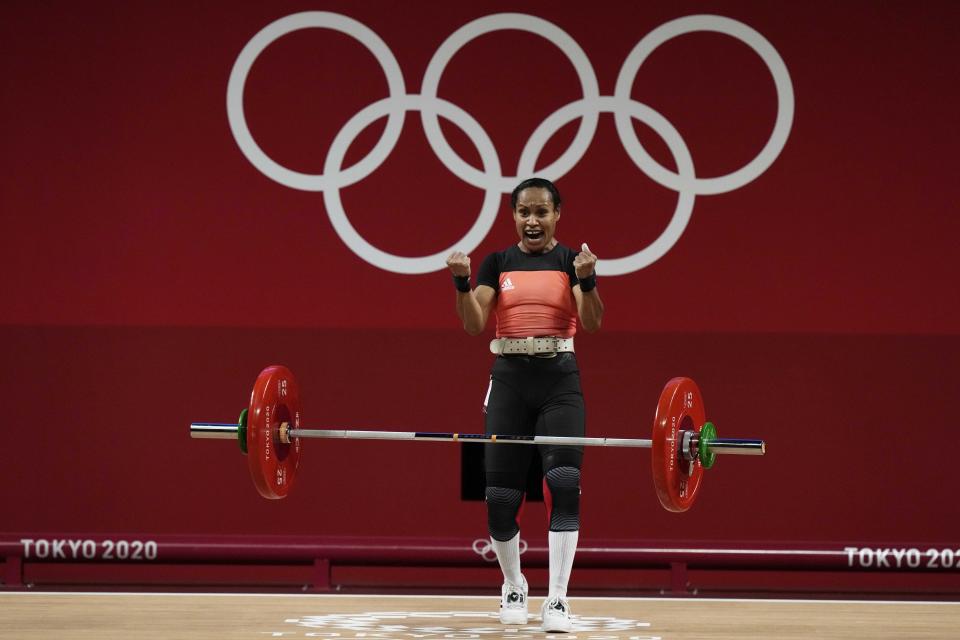 Loa Dika Toua of Papa New Guinea celebrates after a lift in the women's 49kg weightlifting event, at the 2020 Summer Olympics, Saturday, July 24, 2021, in Tokyo, Japan. (AP Photo/Luca Bruno)