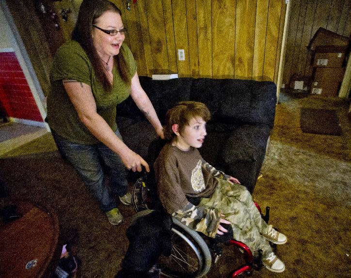 Lori Latch, left, with her son Eric Latch, right, in their home in North Little Rock, Ark., Tuesday, Feb. 4, 2014. Lori Latch, 35, said she was looking forward to having health insurance for the first time since she was a teenager. She and her husband, who is self-employed, have racked up more than $5,000 in bills for emergency room visits. Arkansas’ plan for expanding Medicaid by buying private insurance policies for the poor instead of adding them to the rolls was heralded as a model for convincing more Republican-leaning states to adopt a key part of President Barack Obama’s health care overhaul. But less than a year after its approval, the program that has extended health insurance to 83,000 people is on the brink of being abandoned. (AP Photo/Brian Chilson) (AP Photo/Brian Chilson)