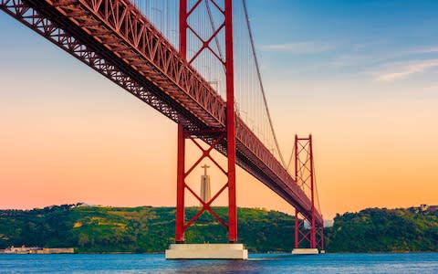 Christ the King, seen behind the 25 de Abril Bridge - Credit: Getty