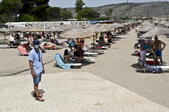 An employee wears a face mask at a beach of Varkiza as Greece gradually eases lockdown restrictions (Getty Images)