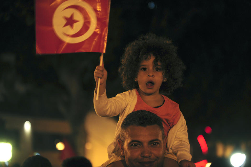 A crowd gathers on Tunis' main avenue, Sunday, Oct. 13, 2019. Tunisian polling agencies are forecasting that conservative law professor Kais Saied has overwhelmingly won the North African country's presidential election. (AP Photo/Hassene Dridi)