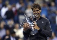 Rafael Nadal of Spain bites his trophy after defeating Novak Djokovic of Serbia in their men's final match at the U.S. Open tennis championships in New York, September 9, 2013. REUTERS/Eduardo Munoz
