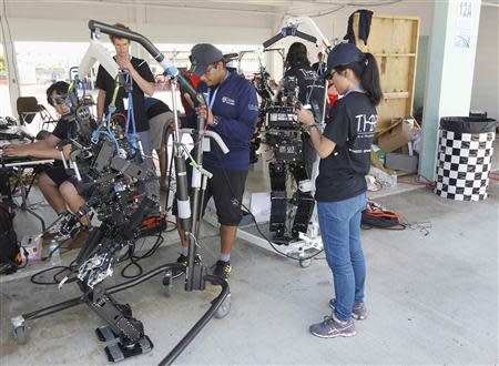 Members of team THOR (Tactical Hazardous Operations Robot) are seen near two of their units in the group's preparation area in Homestead, Florida December 20, 2013. REUTERS/Andrew Innerarity