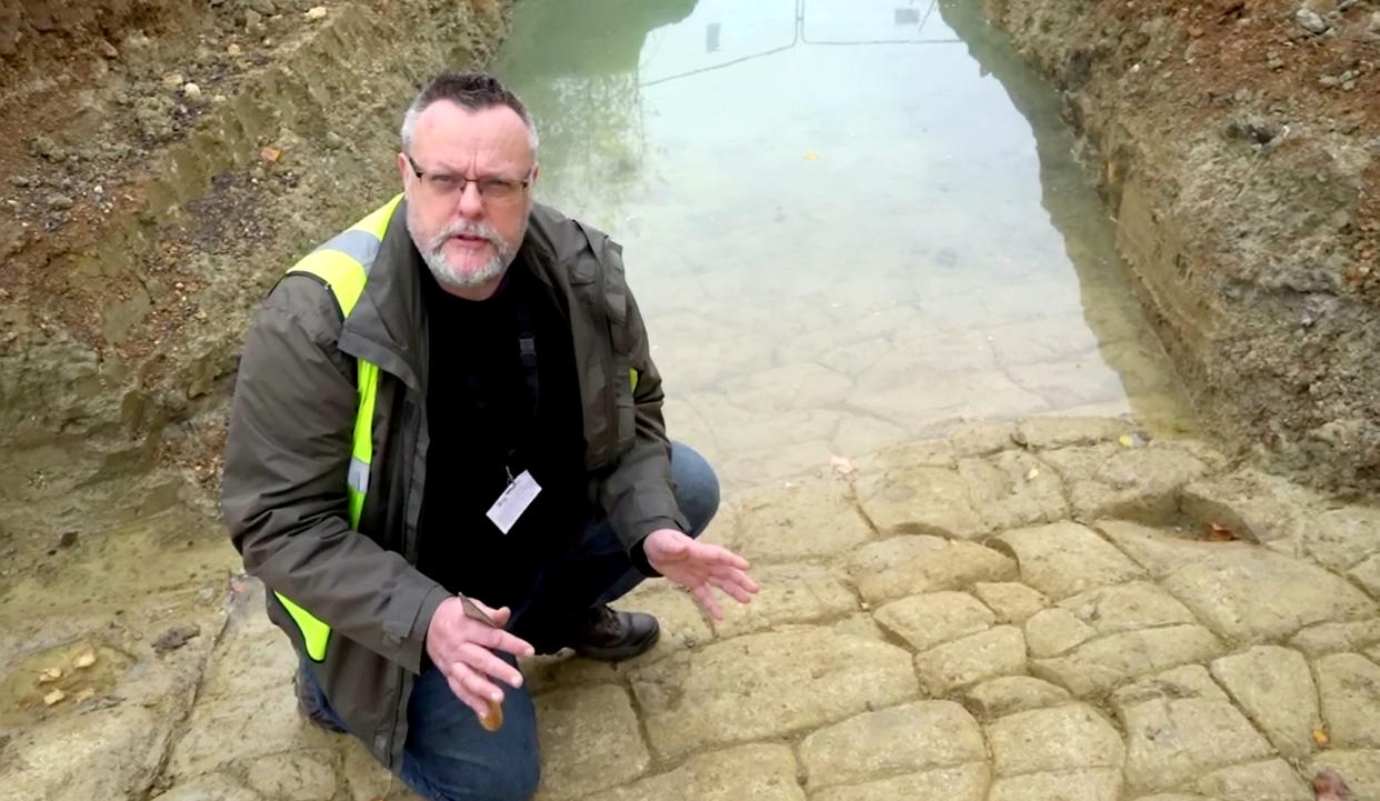 Wychavon Council's archaeology advisor Aidan Smyth on the cobbled path that has lain hidden for almost 2,000 years (SWNS).