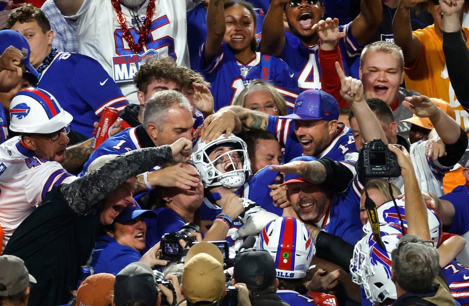 Buffalo Bills rookie tight end Dalton Kincaid jumps into the stands to celebrate the first touchdown of his career.