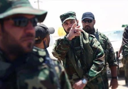 Akram Kaabi, the leader of Nujaba, gestures as he stands with Nujaba fighters in the town of Qayrawan, west of Mosul in this handout picture released by Tasnim News Agency on May 27, 2017. Tasnim News Agency/Handout via REUTERS