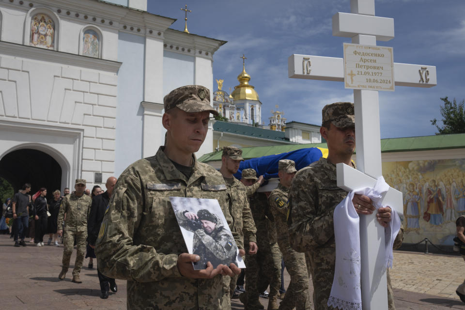 Soldiers carry the coffin of a Ukrainian serviceman, photographer Arsen Fedosenko, who was killed in a battle with the Russian troops, during the funeral ceremony at St. Michael Cathedral in Kyiv, Ukraine, Thursday, June 13, 2024. (AP Photo/Efrem Lukatsky)
