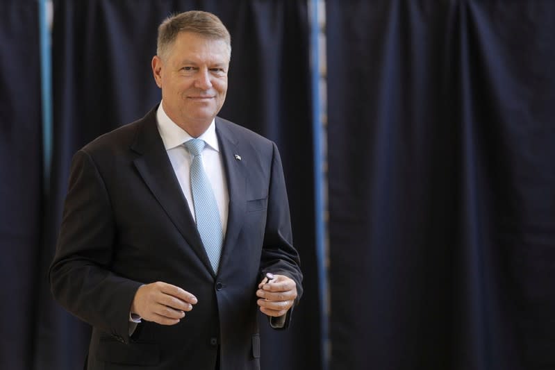 Incumbent candidate Klaus Iohannis smiles after casting his ballot in the first round of a presidential election