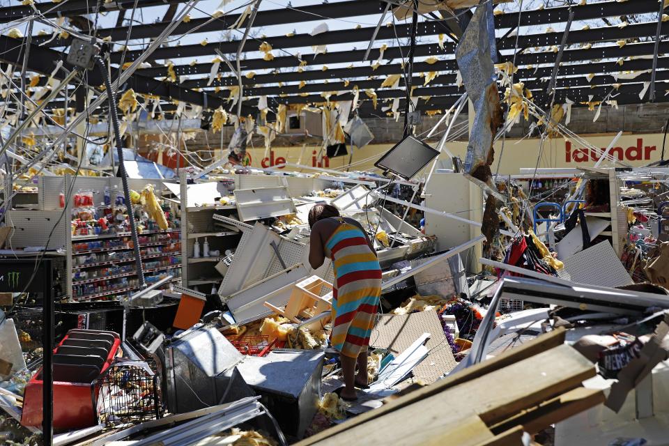 Una mujer camina entre los escombros de una tienda dañada el jueves 11 de octubre de 2018 tras el paso del huracán Michael en Springfield, Florida. (AP Foto/David Goldman)