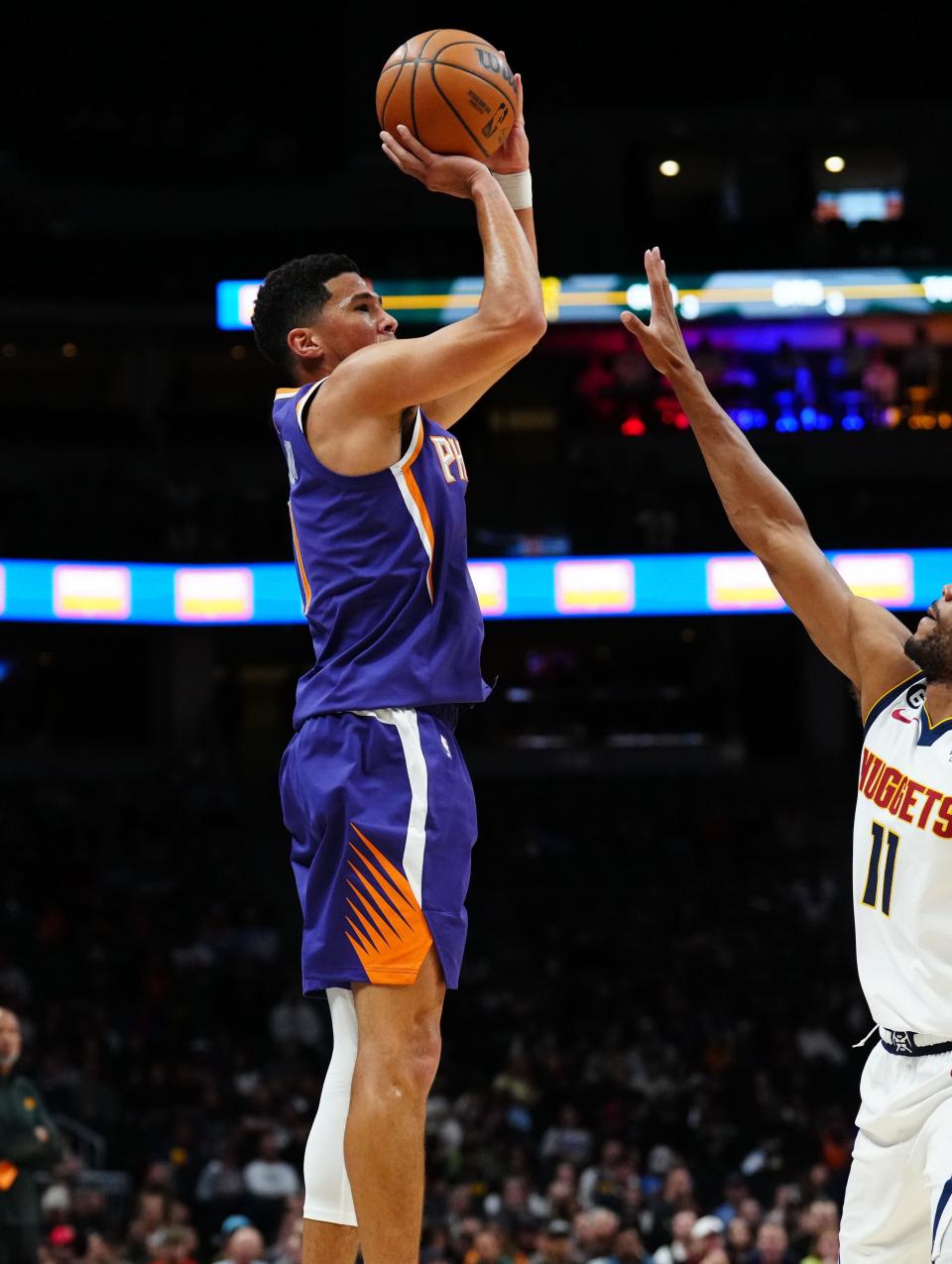 Oct 10, 2022; Denver, Colorado, USA; Phoenix Suns guard Devin Booker (1) shoots over Denver Nuggets forward Bruce Brown (11) in the first quarter at Ball Arena.