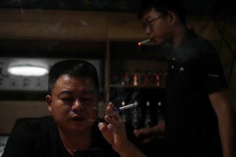 Guo Hui smokes a cigarette at his office in Guangzhou
