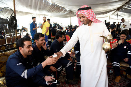 Traditional Arabic coffee is offered as Kuwait Oil and Petrochemical Industries Union workers and employees sit in a shaded area on the first day of an official strike in Ahmadi, Kuwait April 17, 2016. REUTERS/Stephanie McGehee