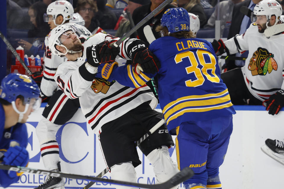 Chicago Blackhawks center Jason Dickinson (17) and Buffalo Sabres defenseman Kale Clague (38) collide during the second period of an NHL hockey game, Saturday, Oct. 29, 2022, in Buffalo, N.Y. (AP Photo/Jeffrey T. Barnes)