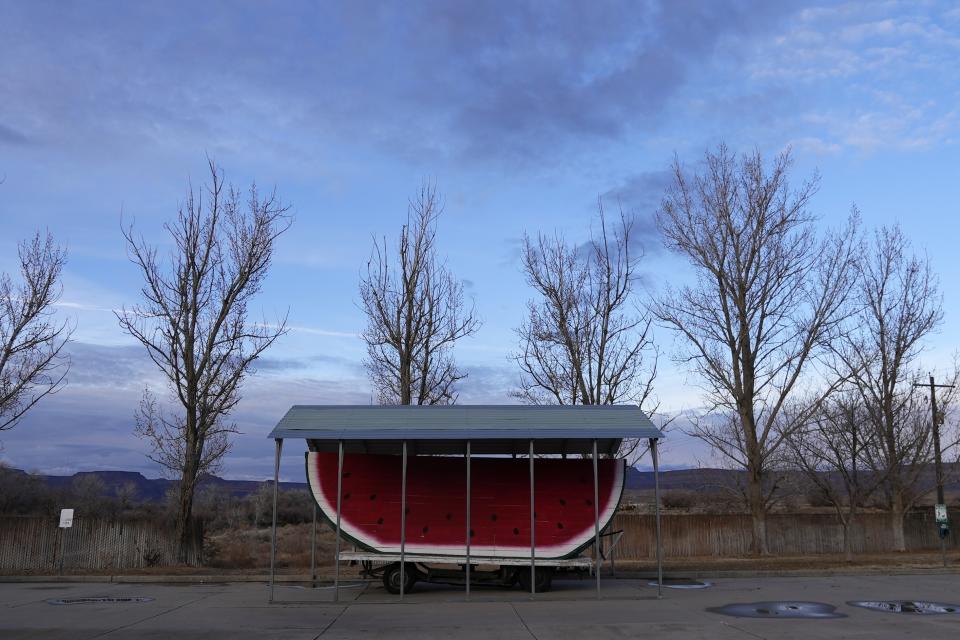 A large replica of a watermelon sits in an empty parking lot Thursday, Jan. 25, 2024, in Green River, Utah. An Australian company and its U.S. subsidiaries are eyeing a nearby area to extract lithium, metal used in electric vehicle batteries. (AP Photo/Brittany Peterson)