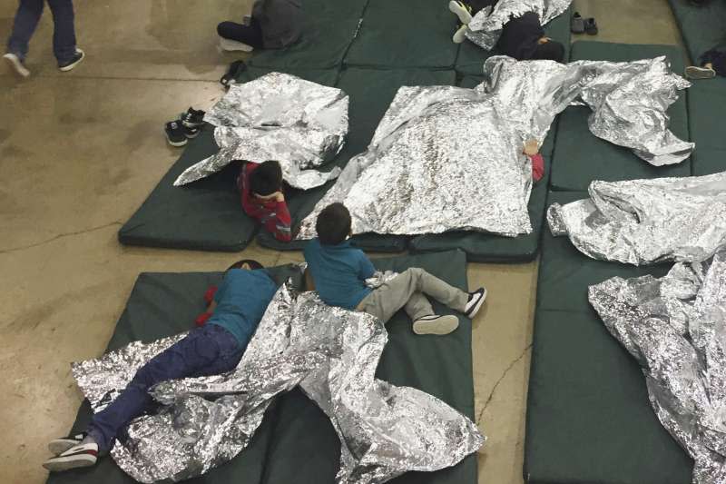 美國德州南部邊境城市麥卡倫的處置中心內，孩童被關在籠子裡，睡在地板上，蓋著鋁箔毯（美聯社）