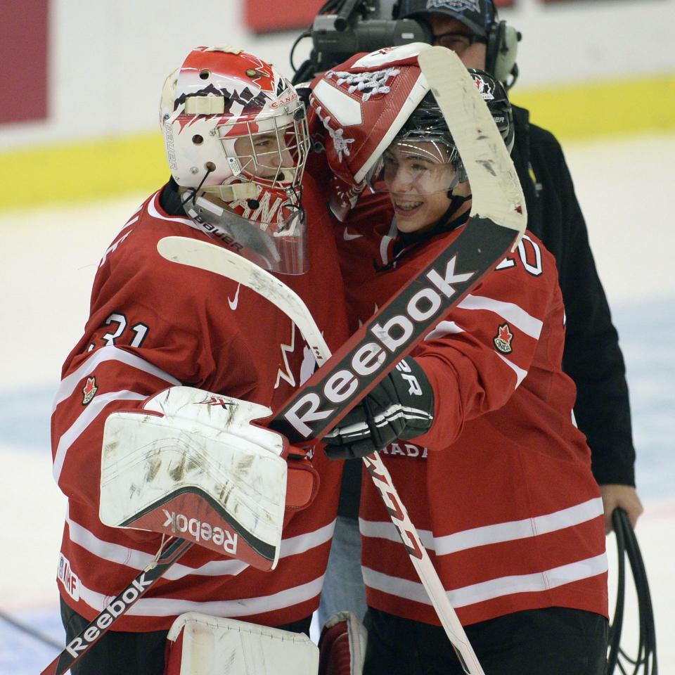 Canada's Zachary Fucale, left, and Charles Hubon celebrate their win over Switzerland in a quarterfinal match at the world junior hockey tournament in Malmo, Sweden, Thursday, Jan 2, 2014. (AP Photo/The Canadian Press, Frank Gunn)