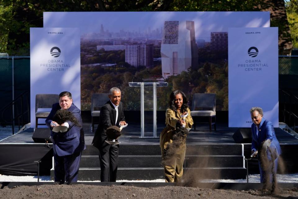 Former President Barack Obama, left, and former first lady Michelle Obama toss shovels of dirt during a groundbreaking ceremony for the Obama Presidential Center Tuesday, Sept. 28, 2021, in Chicago. - Credit: AP