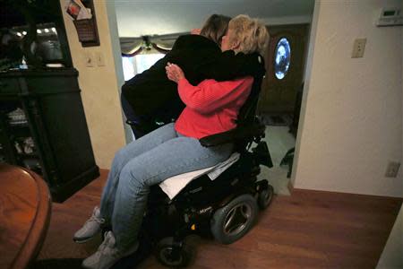 Sandy Wright gets a hug from Jessica Haynes, her Certified Nursing Assistant, at her home in Peoria, Illinois, November 25, 2013. REUTERS/Jim Young