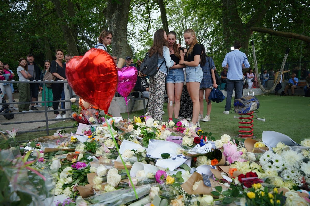 Tributes left near the scene at a lakeside park in Annecy, France, following a knife attack (PA)