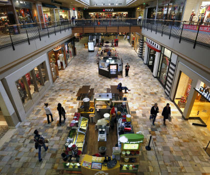 FILE - In this Nov. 28, 2014 file photo, shoppers look for deals inside the Flatiron Crossing Mall, a Macerich property in Broomfield, Colo. Mall operator Macerich on Tuesday, March 17, 2015 rejected a $16 billion hostile bid from competitor Simon Property Group and adopted a “poison pill” defense to defend against a takeover. (AP Photo/Brennan Linsley, File)