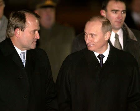 FILE PHOTO Russian President Vladimir Putin (R) smiles at Ukrainian President's administration head Viktor Medvedchuk as Putin arrives in Kiev, January 27, 2003. REUTERS/Alexander Natruskin/File Photo