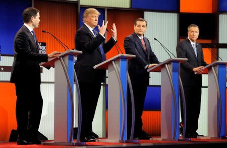 Donald Trump shows off the size of his hands as rivals Marco Rubio, Ted Cruz and John Kasich look on at the start of the Republican presidential candidates debate in Detroit. REUTERS/Jim Young