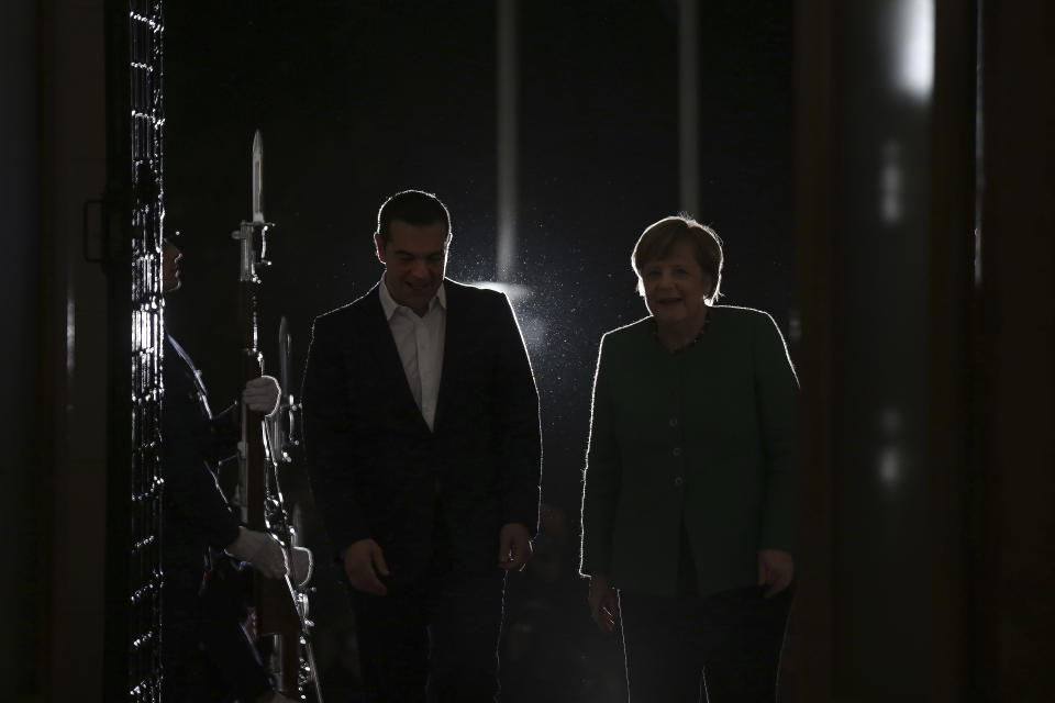 Greek Prime Minister Alexis Tsipras, left, and German Chancellor Angela Merkel walk during a welcome ceremony in Athens, Thursday Jan. 10, 2019. Merkel is in Greece for talks. (AP Photo/Petros Giannakouris)