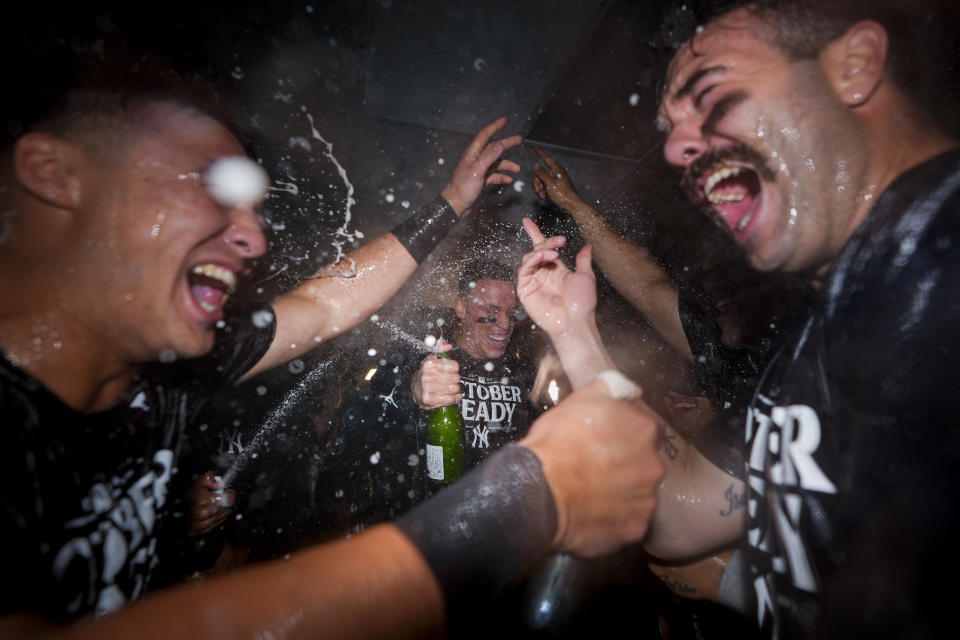 New York Yankees' Aaron Judge, center, celebrates clinching a playoff spot with teammates, including catcher Austin Wells, right, after a 2-1 win over the Seattle Mariners in a baseball game Wednesday, Sept. 18, 2024, in Seattle. (AP Photo/Lindsey Wasson)