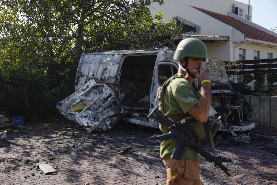 Israeli security personal inspect a site hit by a rocket fired from the Gaza Strip, In a community near the Israeli-Gaza border, southern Israel on Friday, Dec. 1, 2023. (AP Photo/Ariel Schalit)