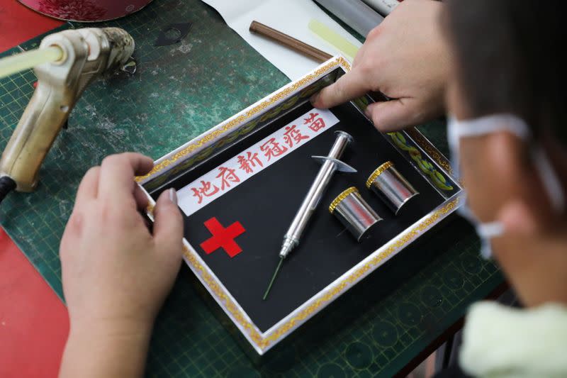 Prayer paraphernalia shop owner Raymond Shieh makes handmade paper vaccines at his shop in Johor Bahru