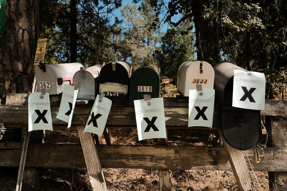 A row of mailboxes tagged with evacuation notices sit along Triangle road during the Oak Fire in Mariposa, on July 23.<span class="copyright">David Odisho—Bloomberg/Getty Images</span>