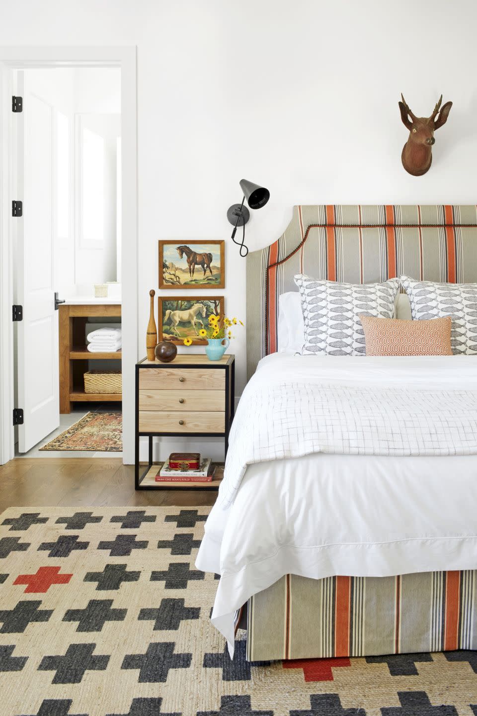 farmhouse bedroom with orange and tan striped upholstered bed