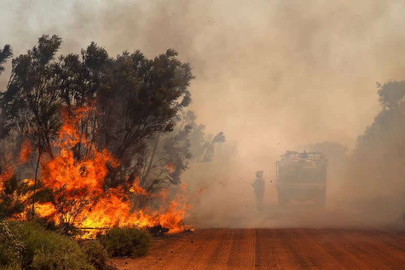 FOTO DE ARCHIVO. Imagen referencial de un bombero junto a un camión de bomberos que apaga las llamas de los incendios forestales en Red Gully, Australia Occidental