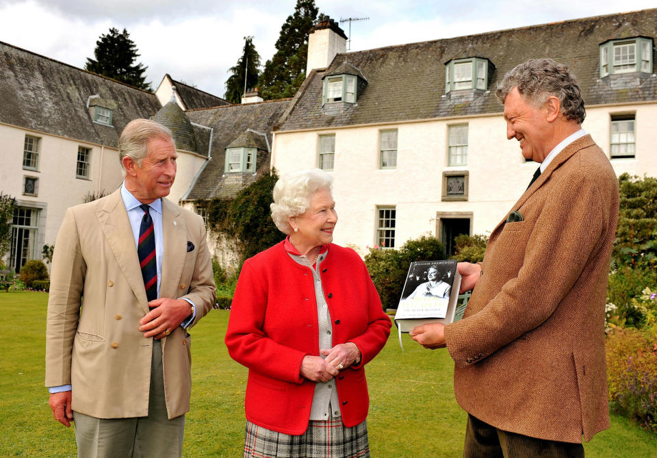 BALLATER, UNITED KINGDOM - SEPTEMBER 2:  Queen Elizabeth II with Prince Charles, Prince of Wales is presented with one of the first copies of 'Queen Elizabeth the Queen Mother, The Official Biography' by author William Shawcross in the garden at Birkhall the Scottish home of the Prince and Duchess of Cornwall on September 2, 2009, Balmoral Estate, Scotland. The book which was written by the renowned author, took six years to complete and tells the story of the Queen Mother through the 20th century.  (Photo by John Stillwell-WPA Pool/Getty Images)