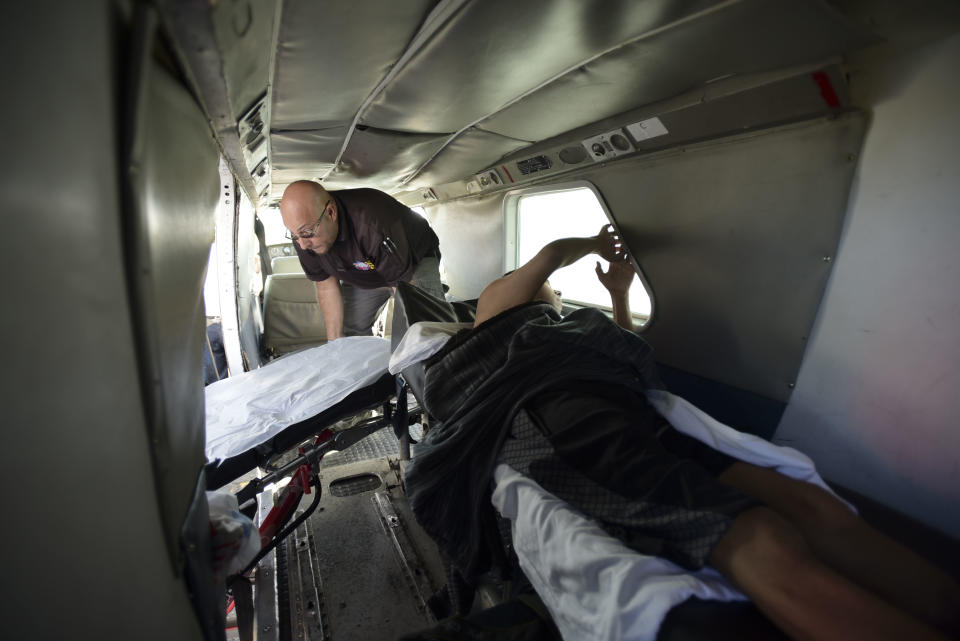 In this Sept. 8, 2018 photo, 42-year-old dialysis patient Sandra Medina looks out a cabin window as she waits inside a plane to be flown to the Puerto Rican mainland, at the airport in Vieques. Doctors amputated half her leg after an infection that worsened months ago. She confides that she is a nervous flyer, and that sometimes she loses hope. (AP Photo/Carlos Giusti)