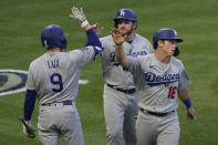 Los Angeles Dodgers' Gavin Lux (9) high-fives Max Muncy (13) and Will Smith (16) after they scored off of a line drive hit by Matt Beaty during the fourth inning of a baseball game against the Los Angeles Angels Saturday, May 8, 2021, in Anaheim, Calif. (AP Photo/Ashley Landis)