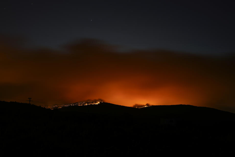 Fire burns in a forest in Dervenohoria, northwest of Athens, early Tuesday, July 18, 2023. (AP Photo/Petros Giannakouris)