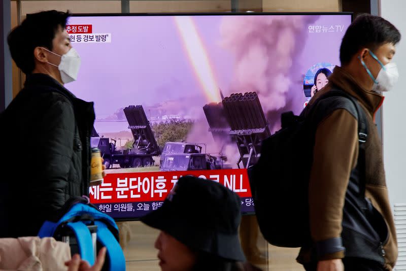 Men walk past a TV broadcasting a news report on North Korea firing a ballistic missile off its east coast, in Seoul