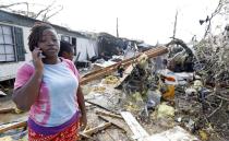 Lanada Miller stands before the remains of her trailer home being ripped apart, while leaving two other trailers with exterior damage, Saturday, Jan. 21, 2017, in Hattiesburg, Miss. The tornado was part of a wall of stormy weather traveling across the region, bringing with it rain and unstable conditions. (AP Photo/Rogelio V. Solis)