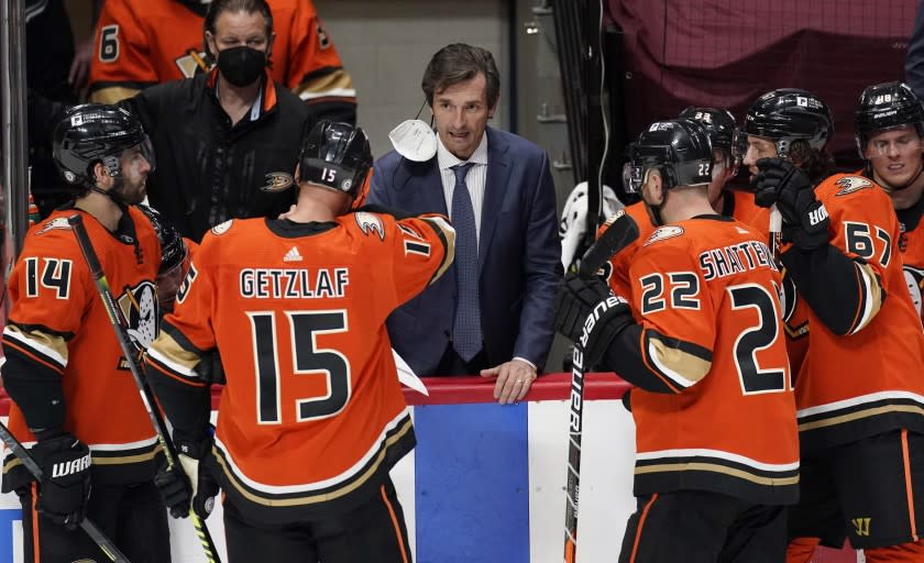 Anaheim Ducks head coach Dallas Eakins, center, talks with, from front left, centers Adam Henrique and Ryan Getzlaf, defenseman Kevin Shattenkirk and center Rickard Rakell in overtime of an NHL hockey game against Colorado Avalanche Saturday, March 6, 2021, in Denver. (AP Photo/David Zalubowski)