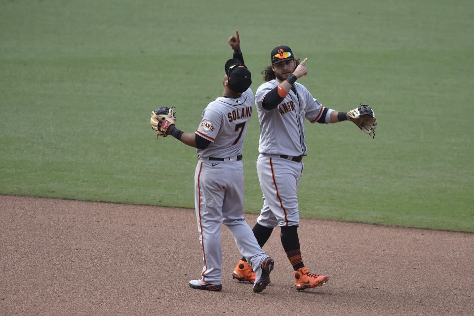 San Francisco Giants' Donovan Solano, left, celebrates with Brandon Crawford after the team's baseball game against the San Diego Padres in San Diego, Wednesday, April 7, 2021. The Giants won 3-2. (AP Photo/Kelvin Kuo)