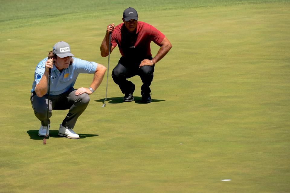 Neal Shipley and Tiger Woods line up their putts on the No. 15 green at the Masters on Sunday.