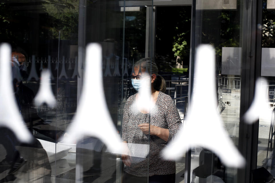 A woman walks through the security gate prior to visit the Eiffel Tower, in Paris, Thursday, June 25, 2020. The Eiffel Tower reopens after the coronavirus pandemic led to the iconic Paris landmark's longest closure since World War II. (AP Photo/Thibault Camus)
