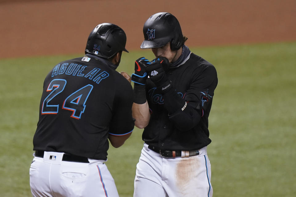 Brian Anderson es felicitado por el venezolano Jesús Aguilar, de los Marlins de Miami, tras empujarlo con un jonrón en el segundo juego de una doble cartelera ante los Nacionales de Washington, el viernes 18 de septiembre de 2020 (AP Foto/Wilfredo Lee)