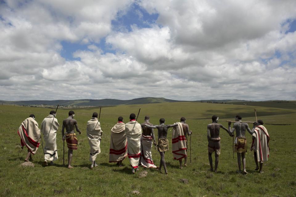 Initiates pose as they walk on a field in Qunu