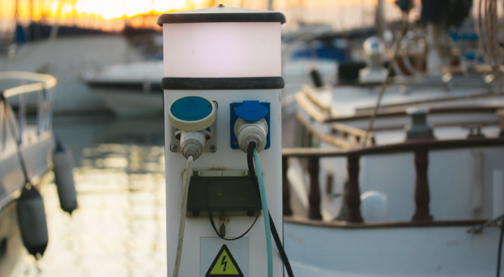 Charging station with electrical outlets for yachts in a harbor. Power socket bollard on pier. Marina theme. Charger cables outdoors. A station for boats in boat station Luxury lifestyle travel voyage. FRZA stock