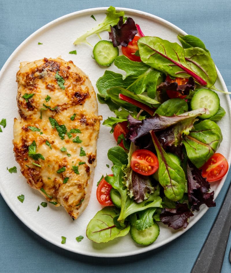5 Ingredient Baked Caesar Chicken on a plate with salad