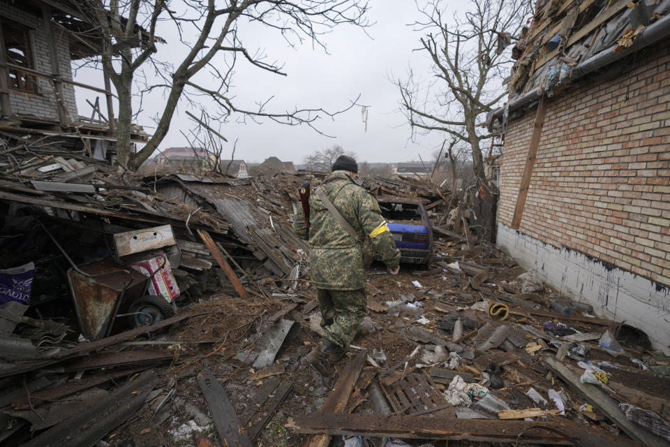 Andrey Goncharuk, 68, a member of territorial defense, walks in the backyard of a house damaged by a Russian airstrike, according to locals, in Gorenka, outside the capital Kyiv, Ukraine, Wednesday, March 2, 2022. Russia renewed its assault on Ukraine's second-largest city in a pounding that lit up the skyline with balls of fire over populated areas, even as both sides said they were ready to resume talks aimed at stopping the new devastating war in Europe.(AP Photo/Vadim Ghirda)